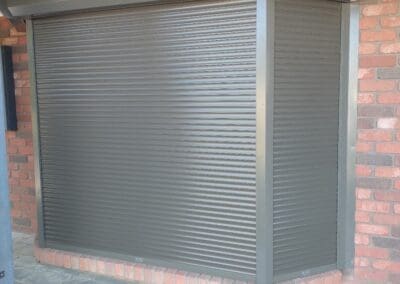 a metal shuttered door on a brick building