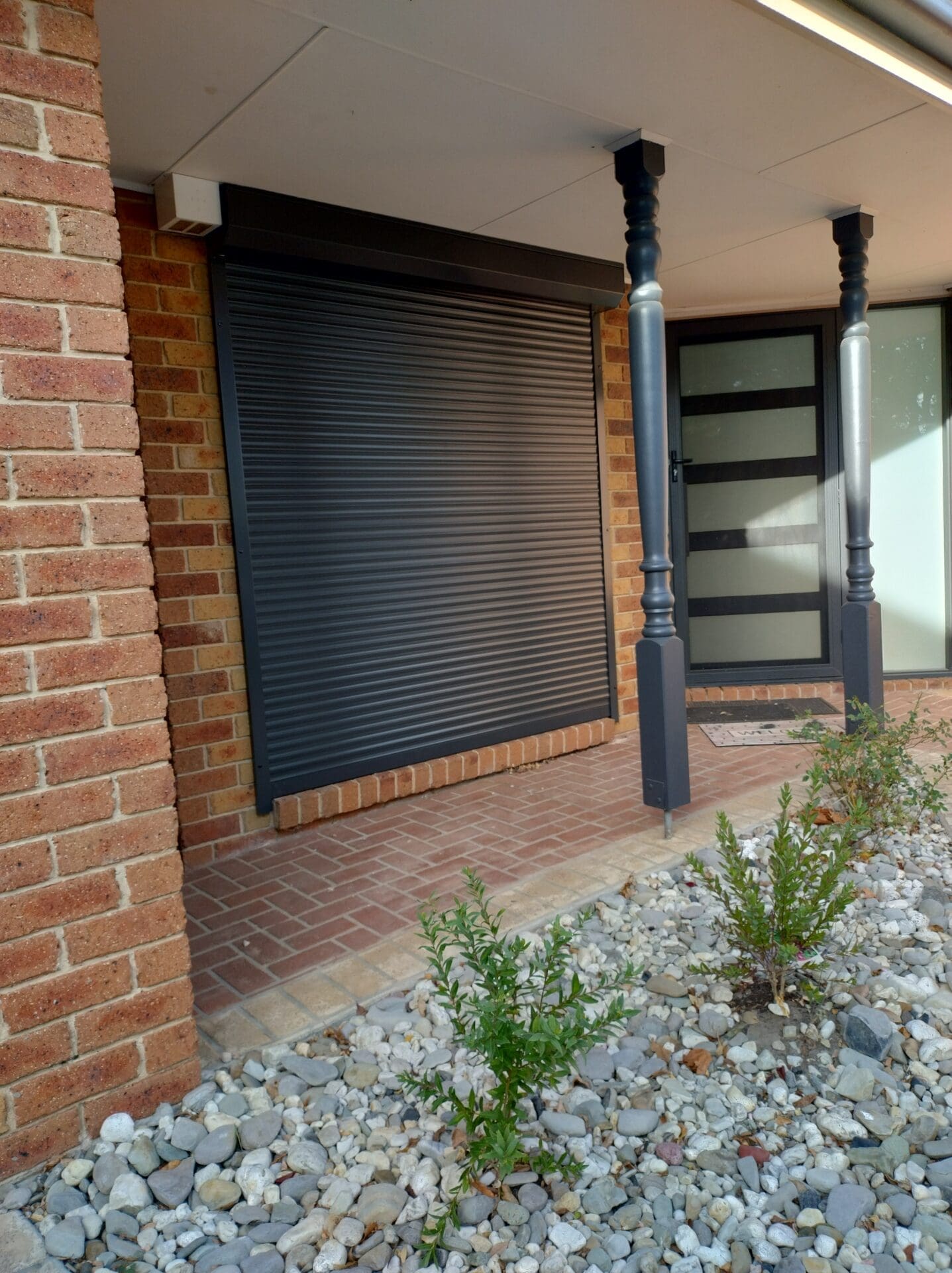 a brick building with a door and a window a brick building with a door and a window