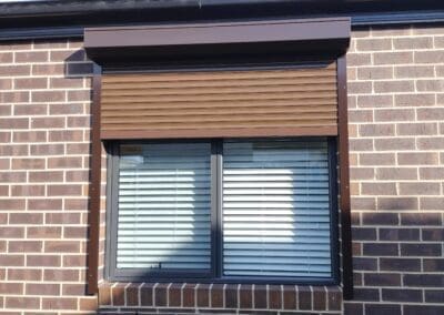a window with blinds on a brick building