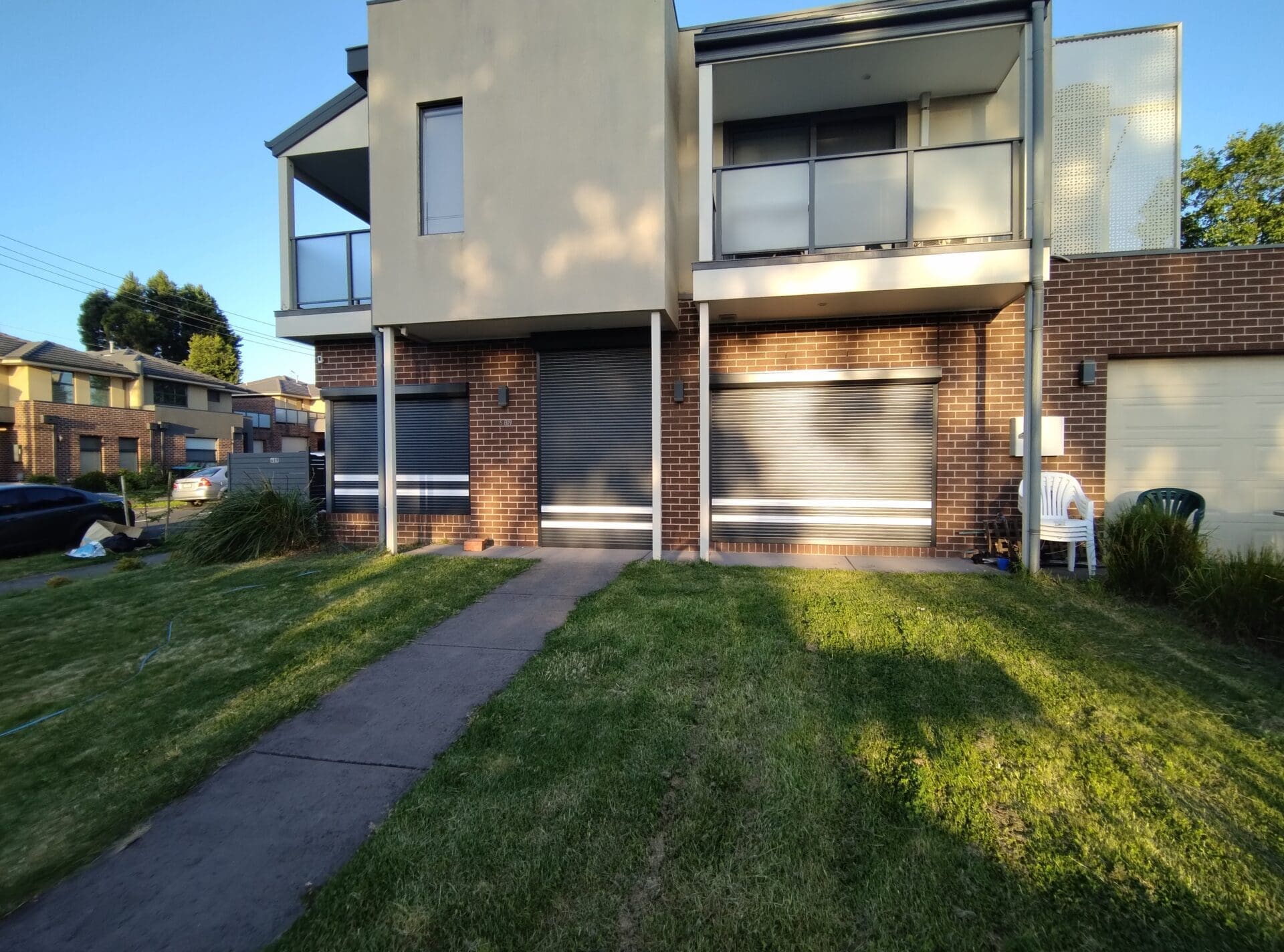 Privacy Roller Shutters a building with a lawn and a sidewalk