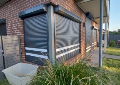 Black shutters with white stripe front of the house